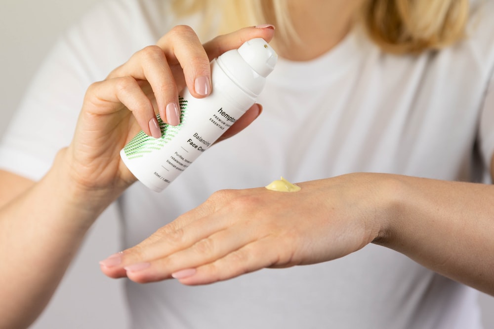 woman putting brown liquid on hand